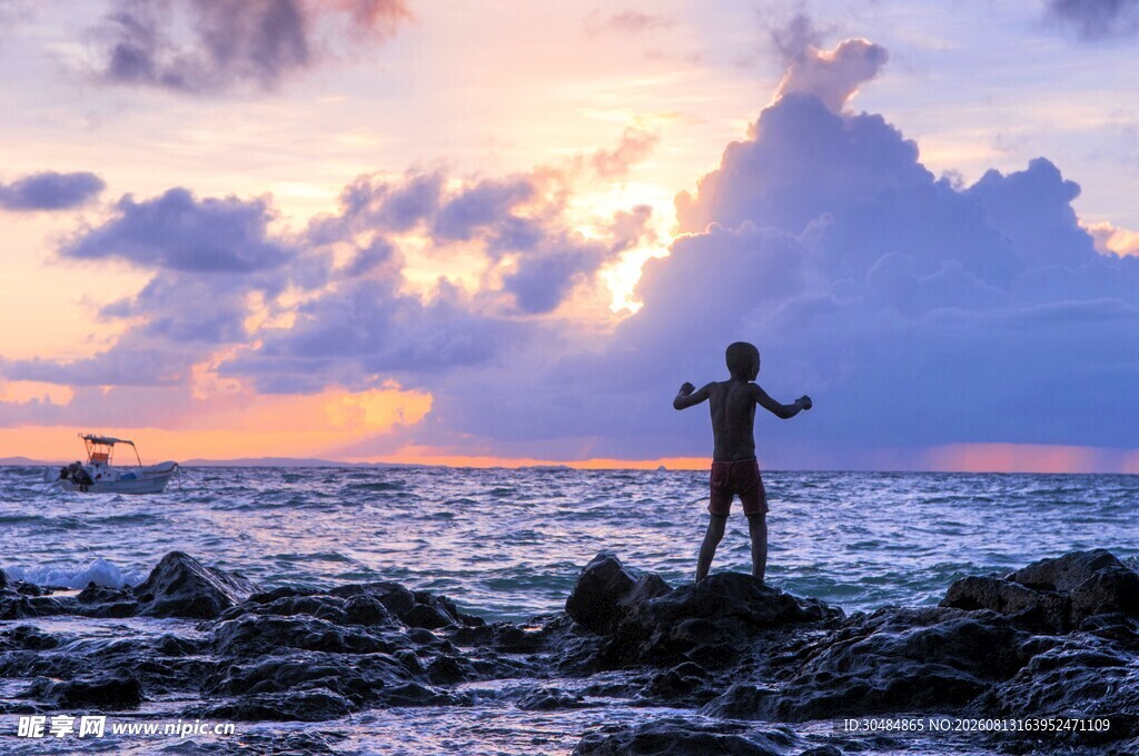 海边少年迎日出舒展身姿