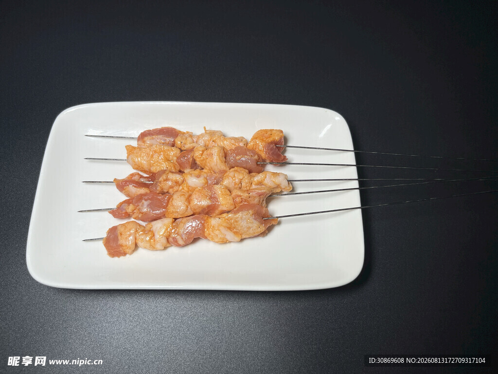 美味鸡肉串摆于白盘上
