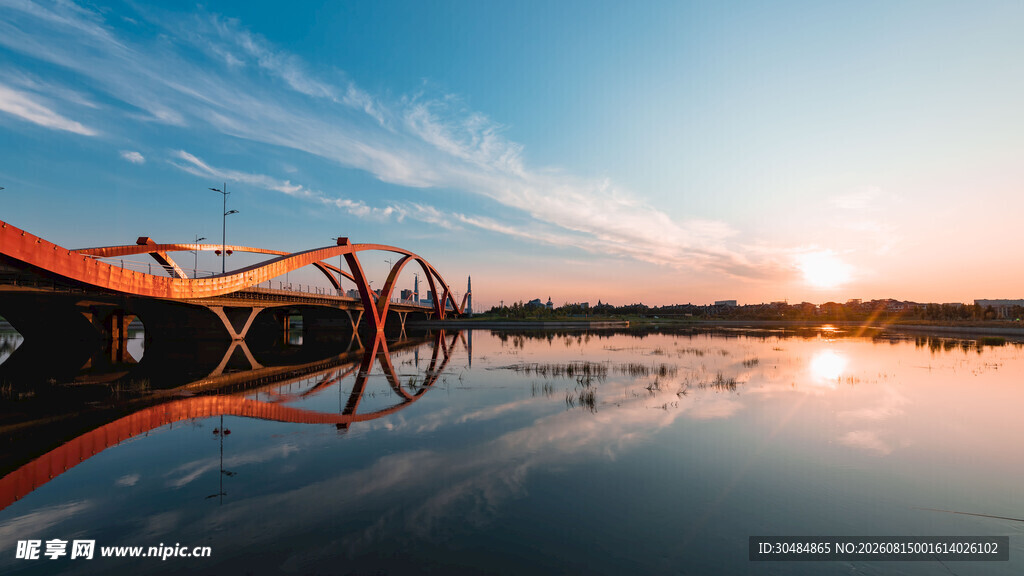 夕阳下的桥梁与平静湖水