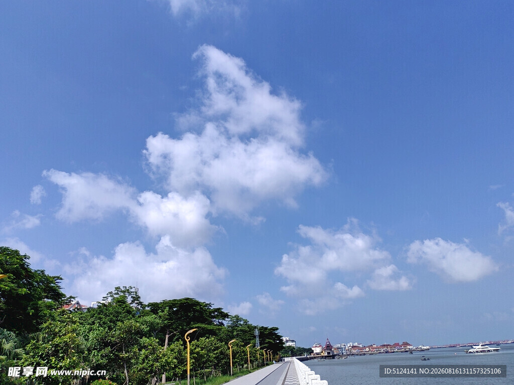 海边蓝天白云绿树风景图