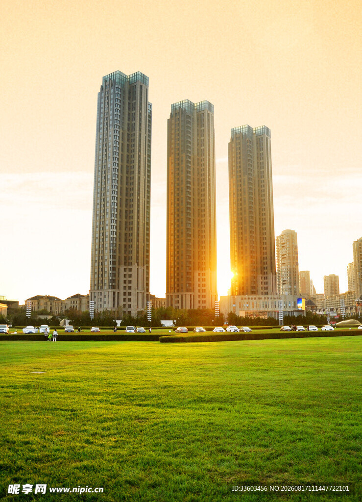 城市草地旁的高楼日落景
