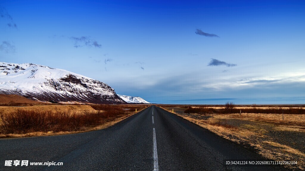 雪覆远山旁的空旷公路
