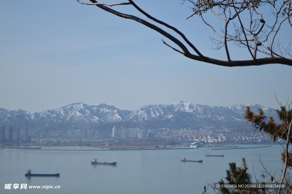 湖畔雪景中的船只与城市