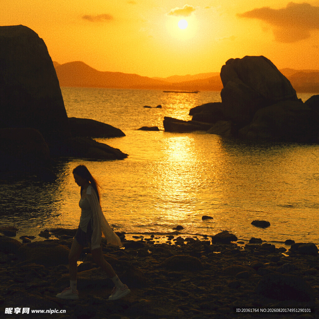 夕阳下海边漫步的女子