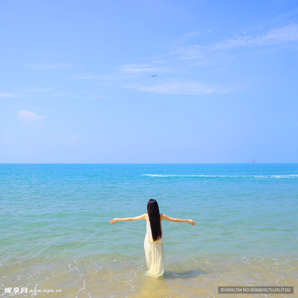 海边女子舒展双臂赏美景