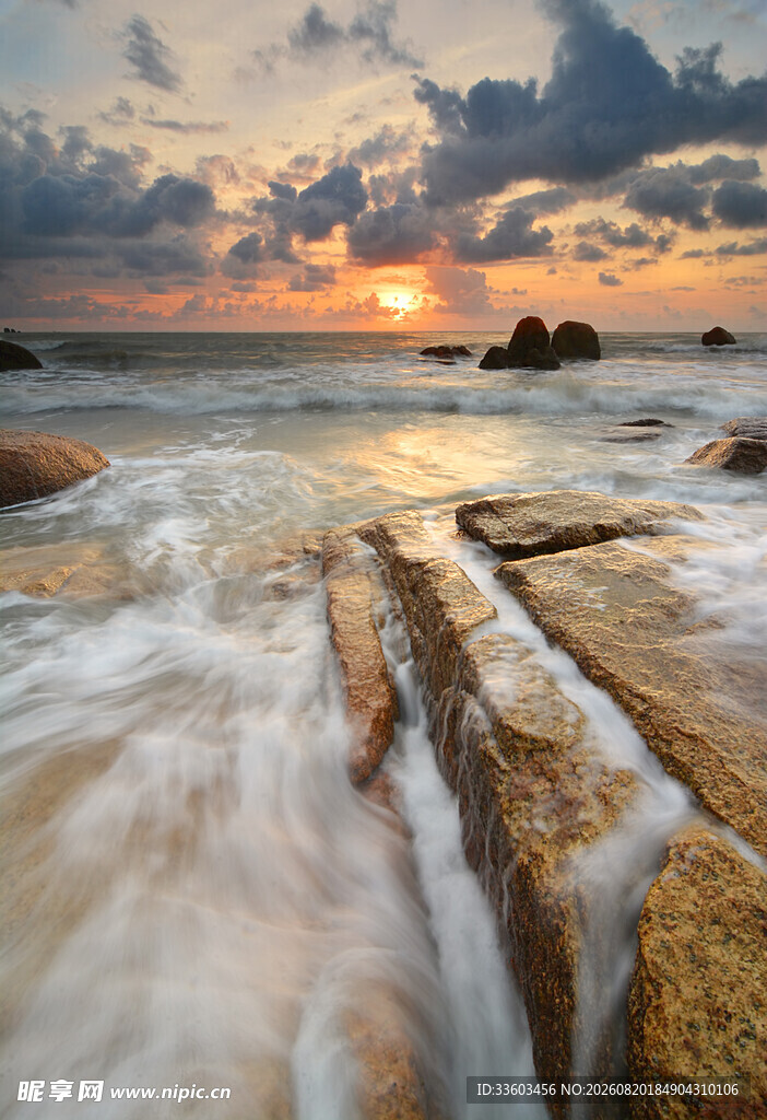 海边日落时的海浪礁石美景