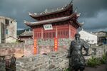 中式古建筑旁的人物雕像