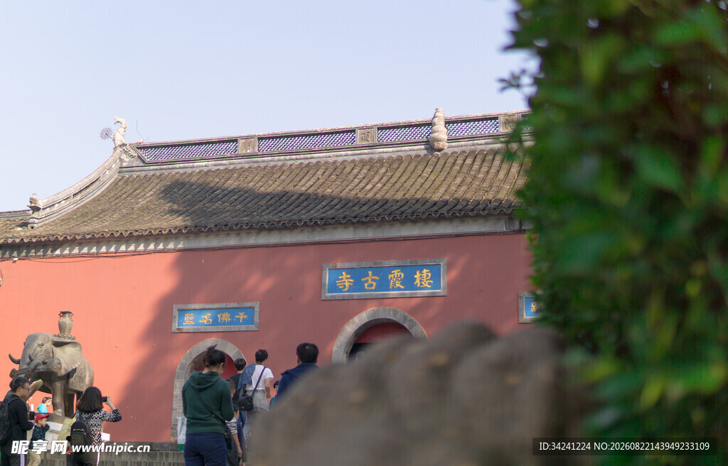 古寺红墙前的游客身影