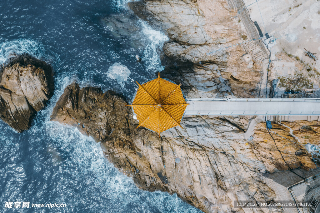 海边岩石上的黄色雨伞