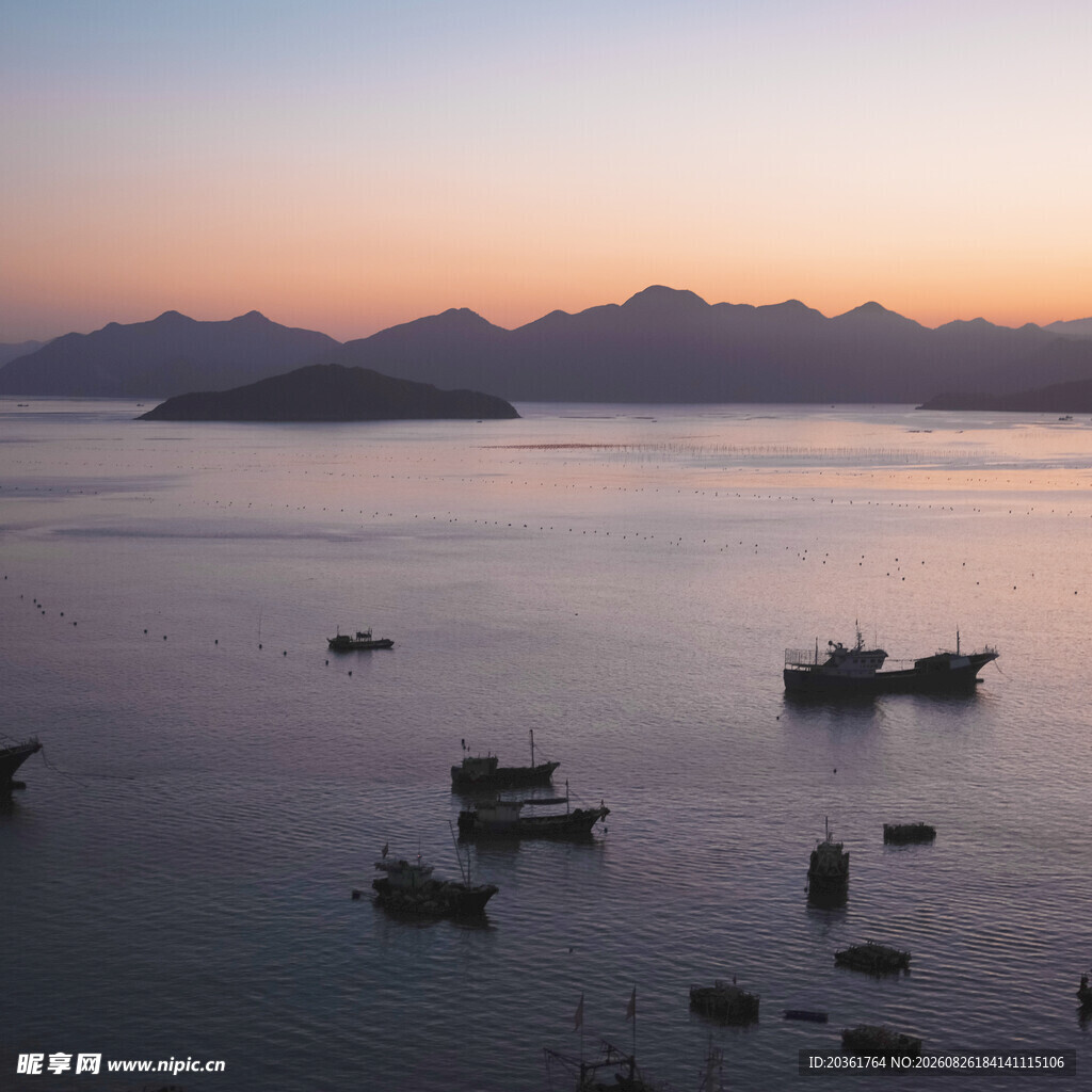 海上暮色中的渔船与远山