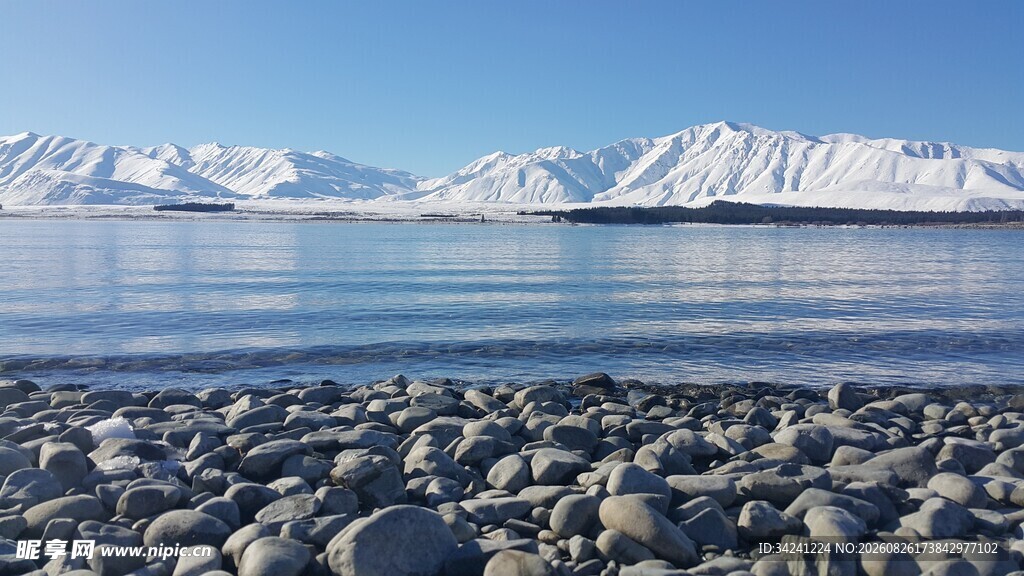 湖畔碎石与远处雪山美景