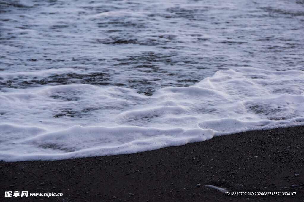 海浪拍打黑色沙滩