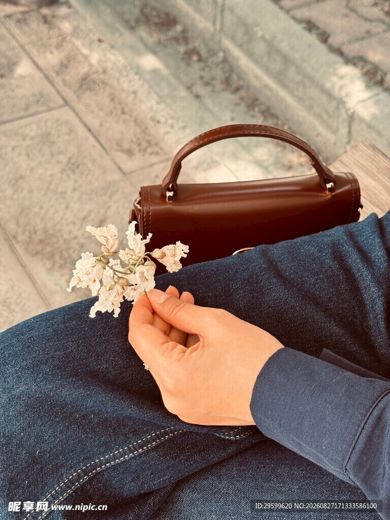 手捧小花与复古手提包