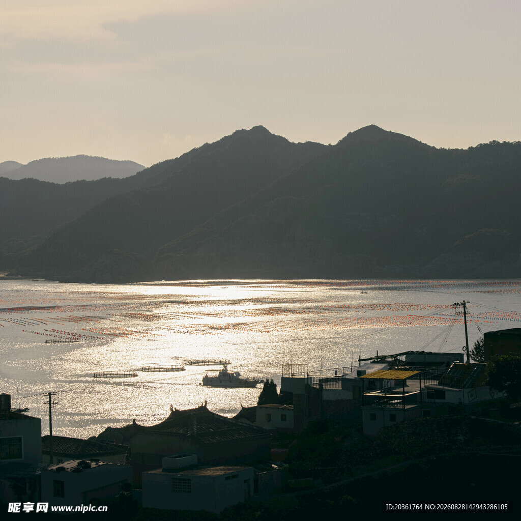 夕阳下的山水与江上船只