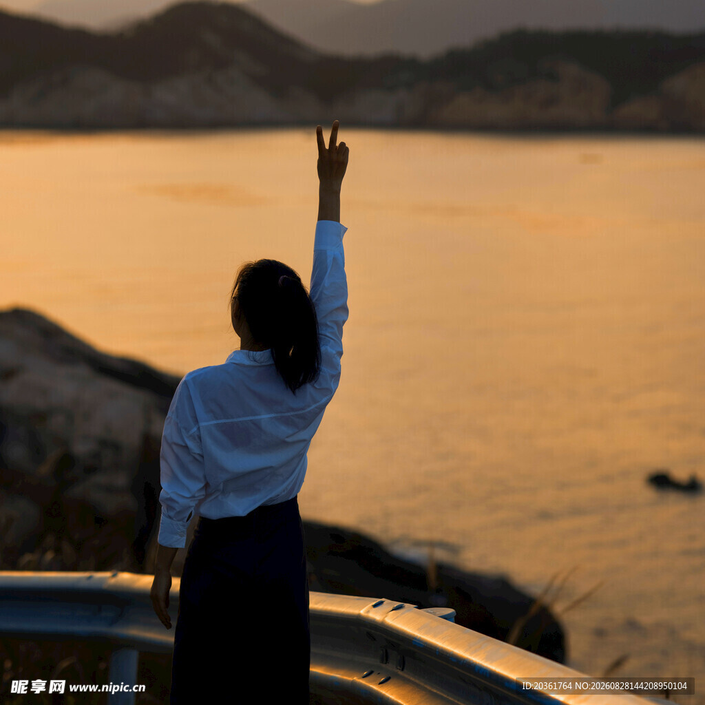 女子海边逆光高举手臂