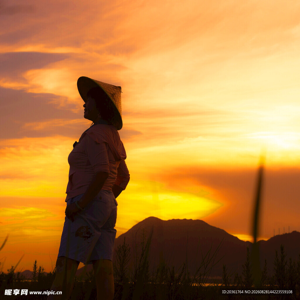 夕阳下戴帽女子的剪影