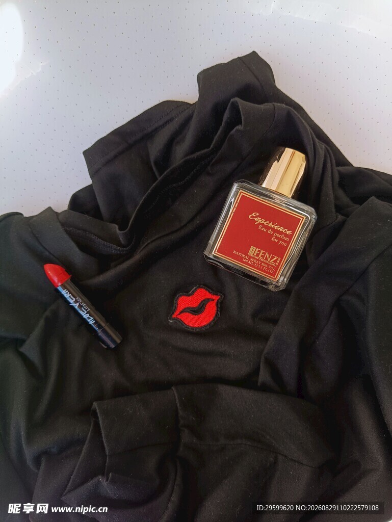 黑色衣物上的香水瓶与笔