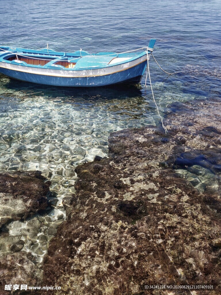 浅滩边停泊的蓝色小船