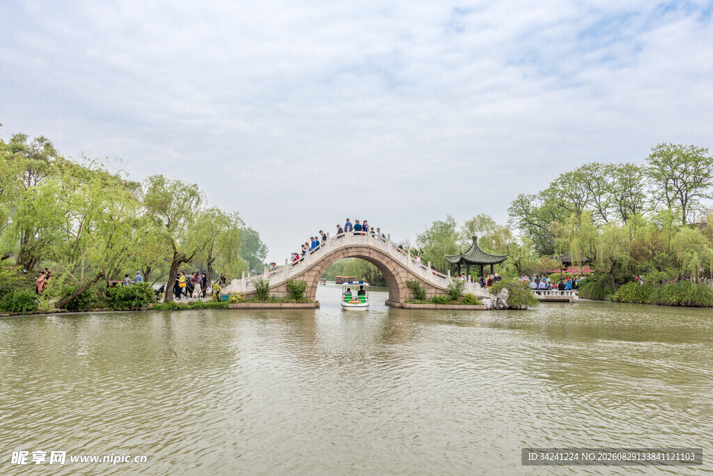 河畔古桥映绿树美景
