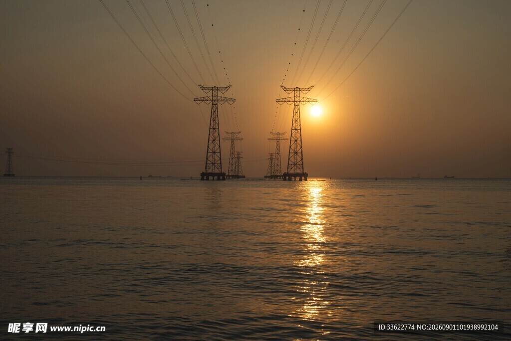 海上夕阳下的输电塔