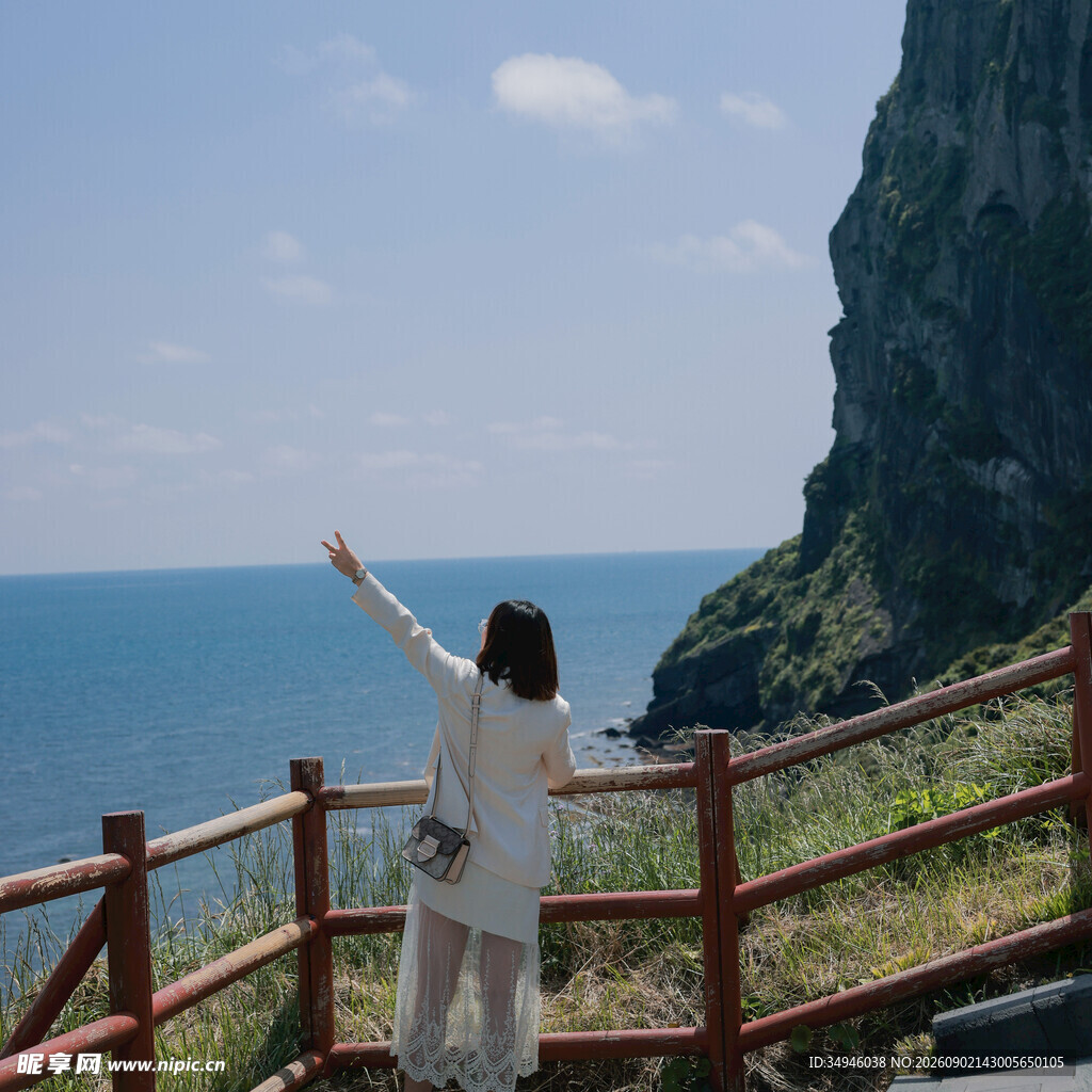 女子海边凭栏舒展身姿
