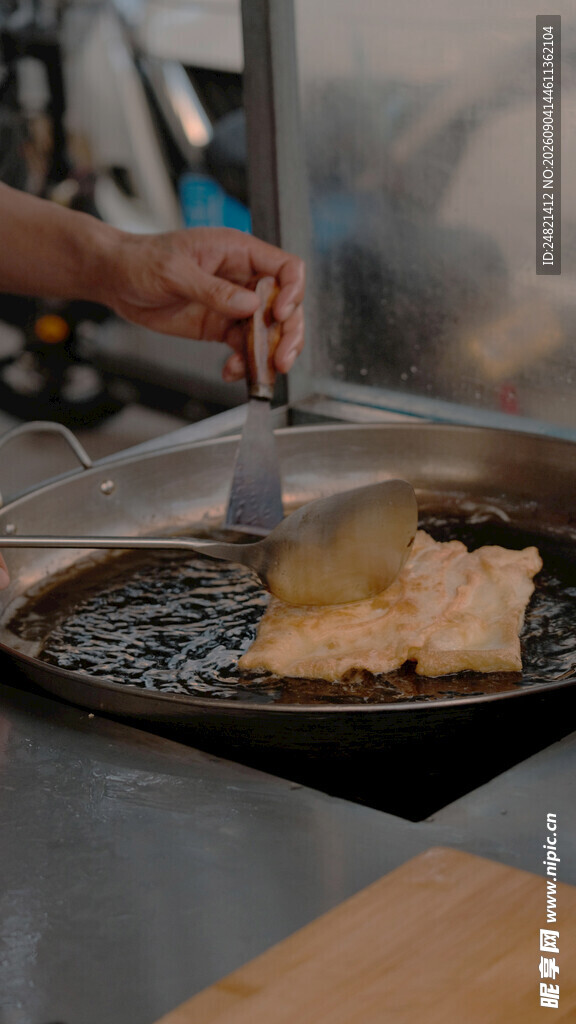 厨师煎制食物于平底锅