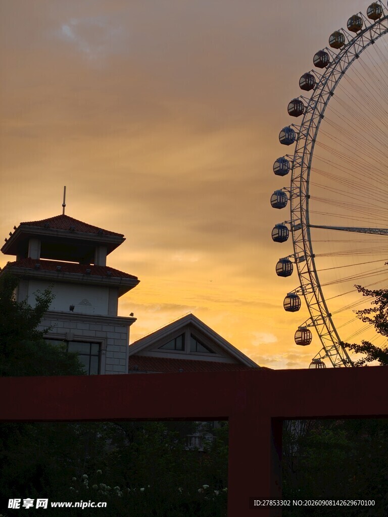 夕阳下的古塔与摩天轮