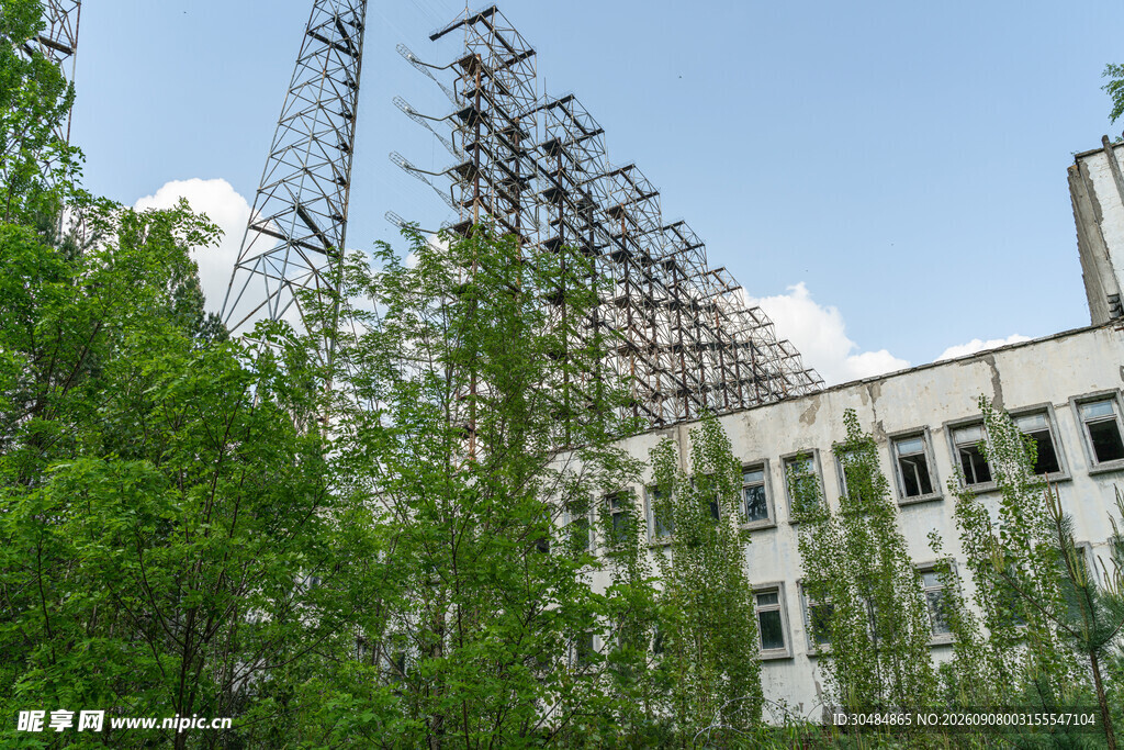 废弃建筑旁的高耸铁塔