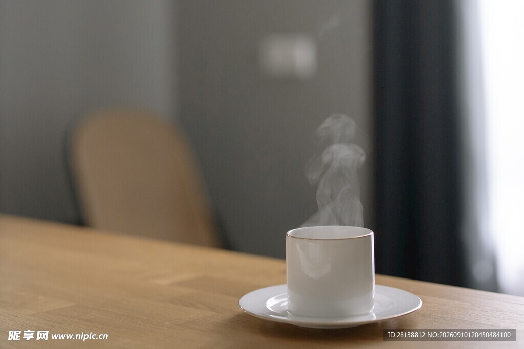 桌上热气腾腾的白色咖啡杯