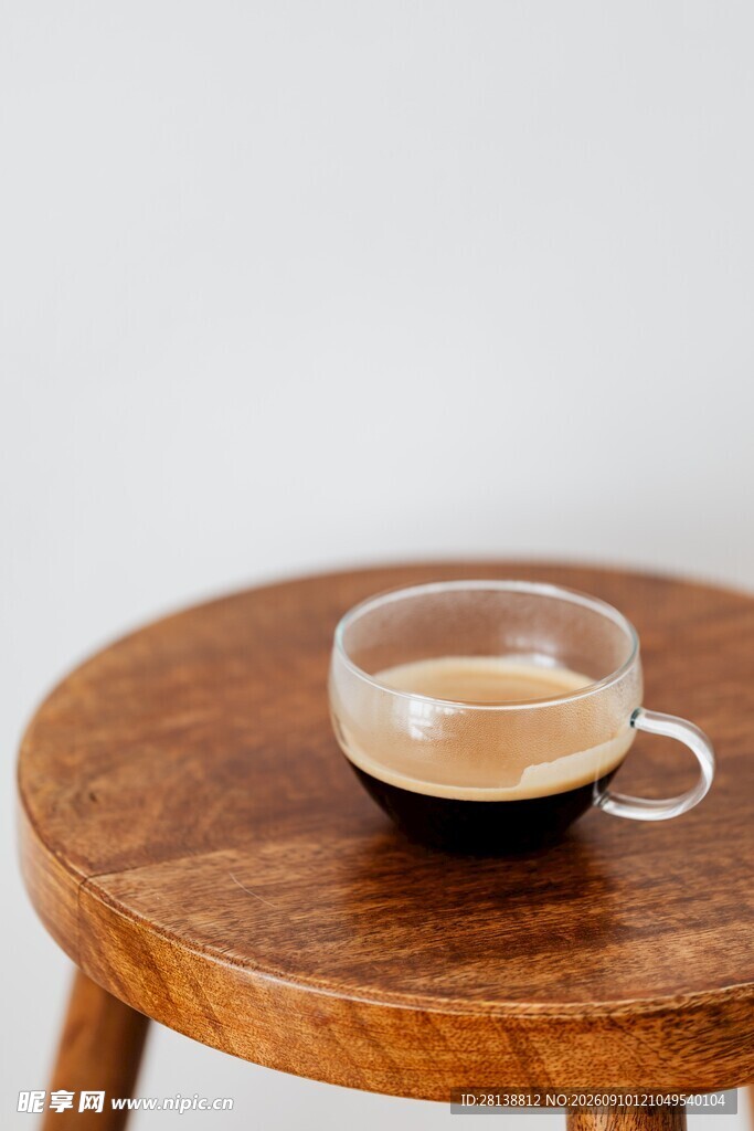 木质圆桌上的透明咖啡杯