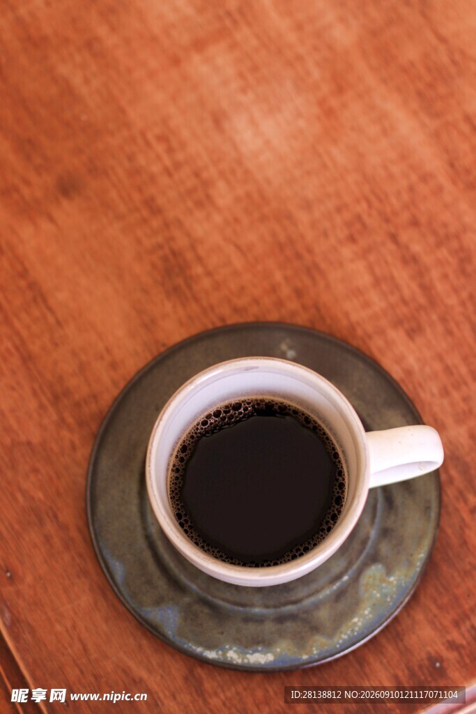 木质桌面上的黑咖啡杯
