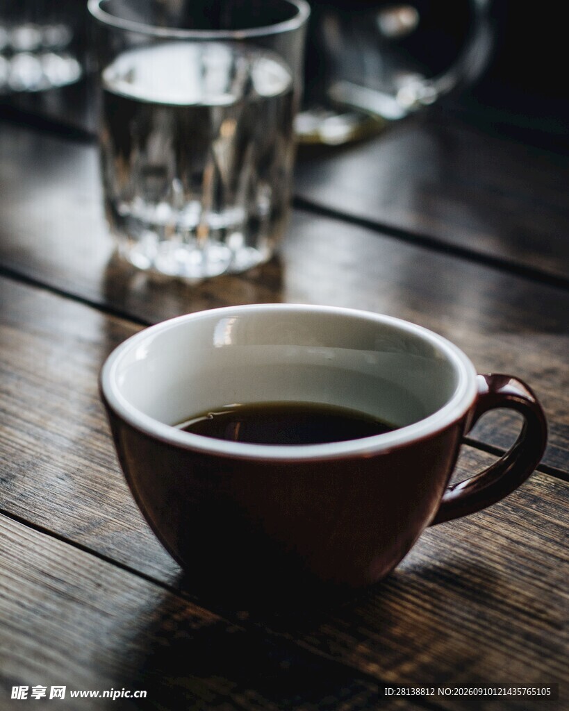 木桌上的咖啡杯与玻璃杯