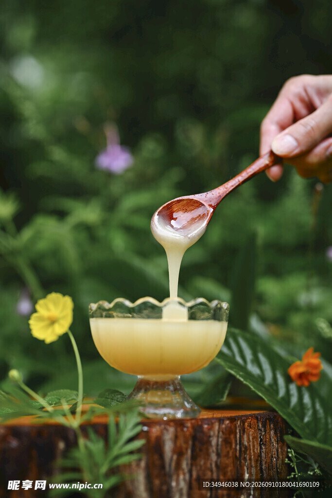 木勺舀取杯中黄色蜂蜜