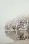 雪覆山丘映于平静湖面