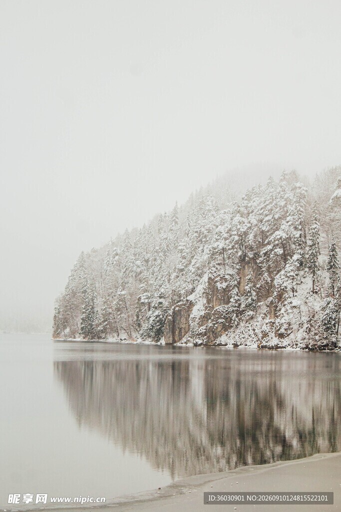 雪覆山丘映于平静湖面