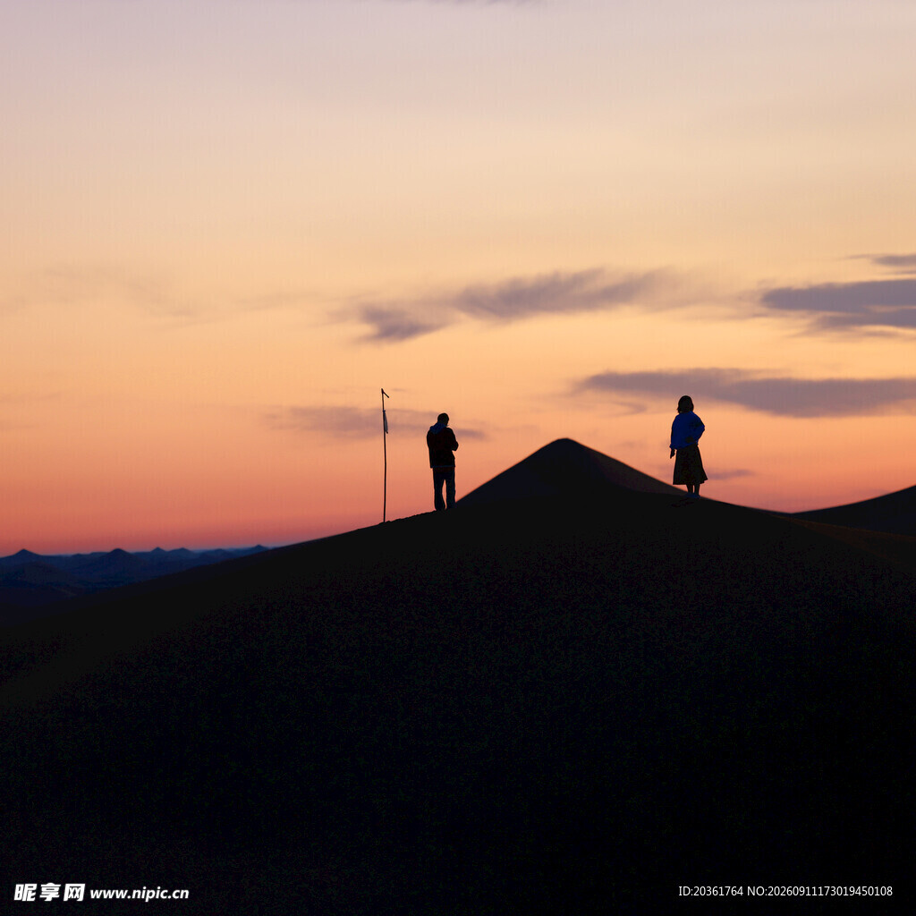 夕阳下的山丘上两人身影