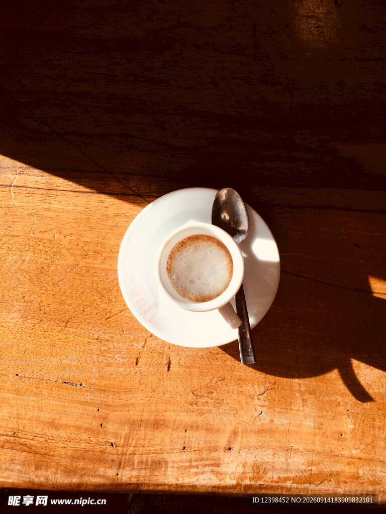 木桌上的咖啡杯与勺子