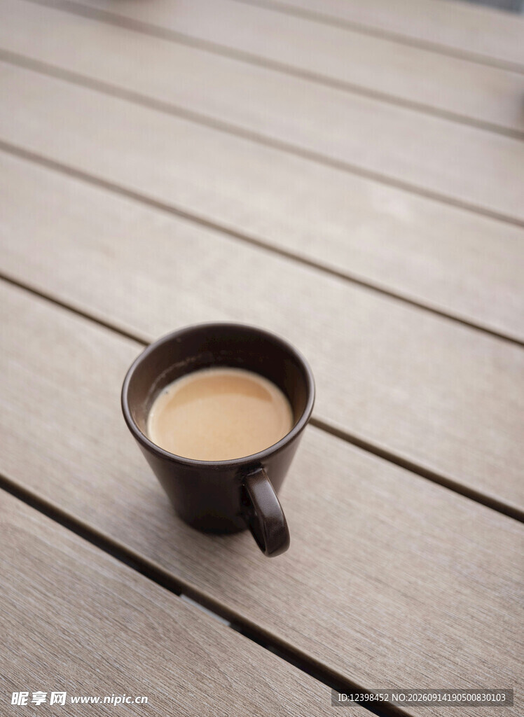 木桌上的黑色咖啡杯