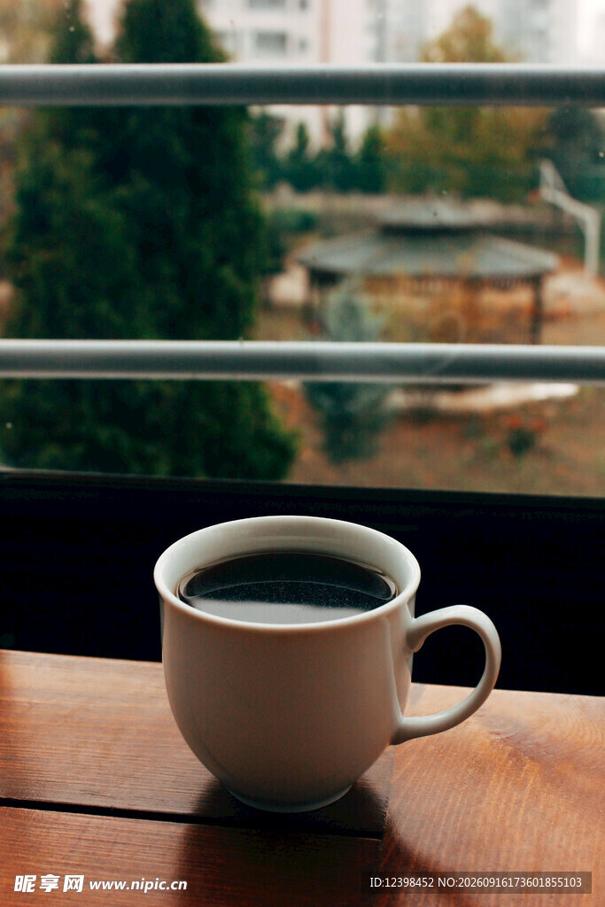 窗边木桌上的一杯热咖啡