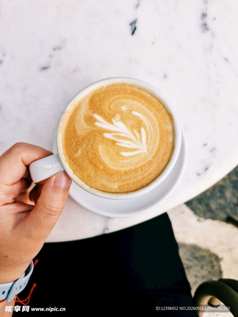 手捧精美拉花咖啡一杯