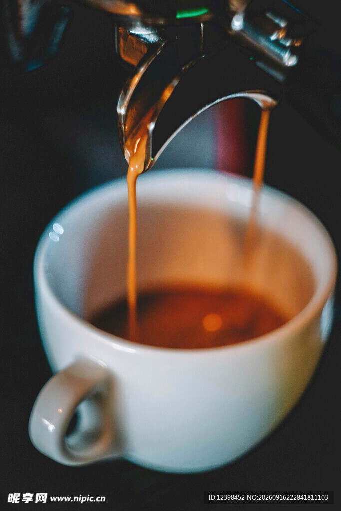 咖啡正倒入白色瓷杯
