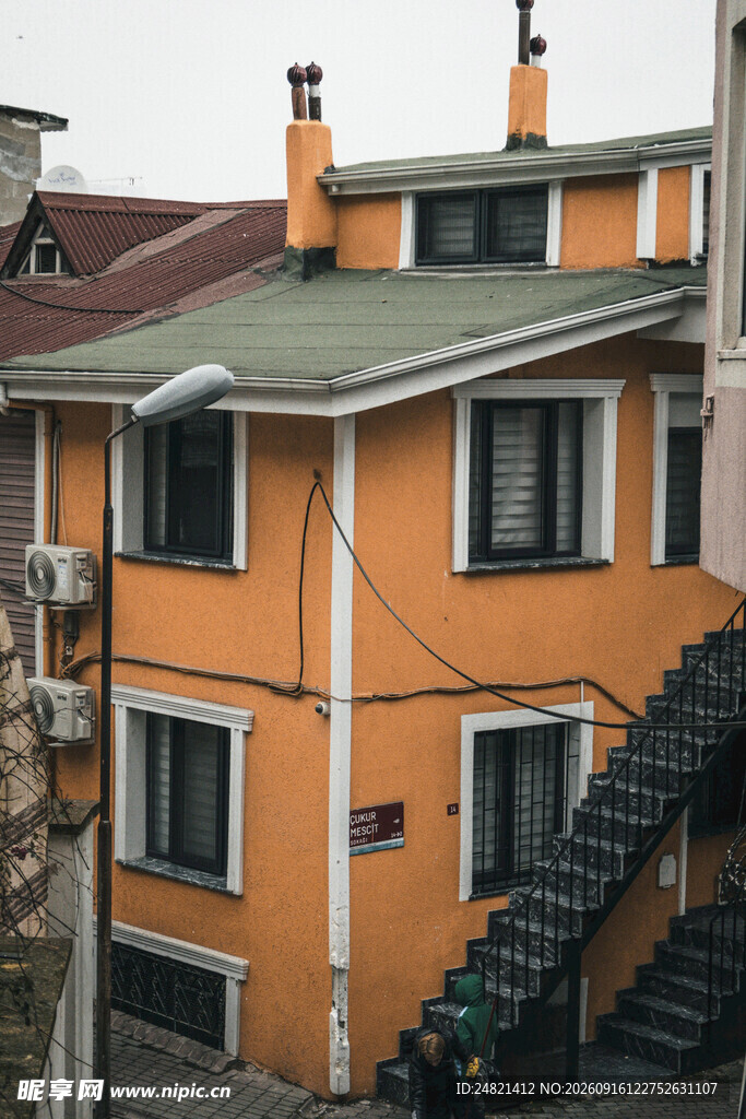 橙黄外墙带烟囱的两层房屋