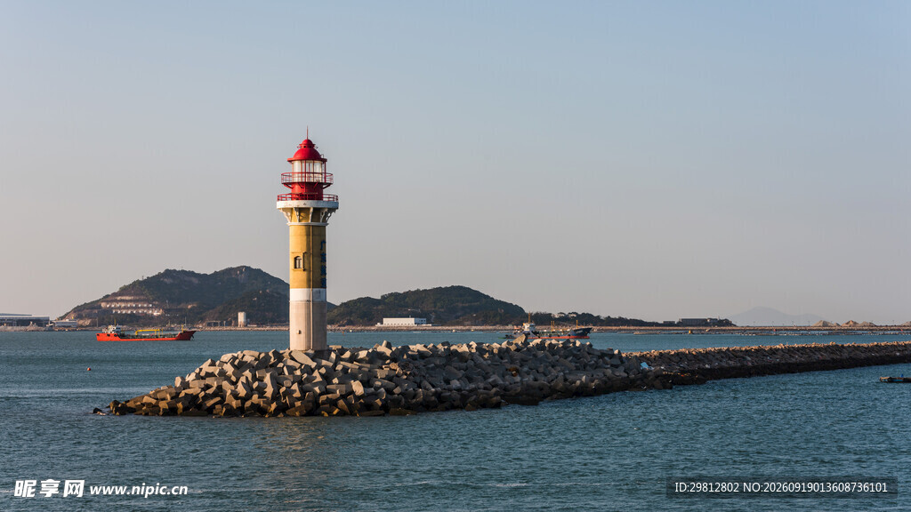 海边灯塔屹立于防波堤