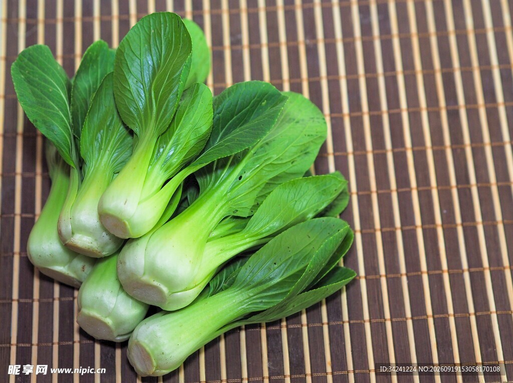 新鲜青菜摆放在竹席上