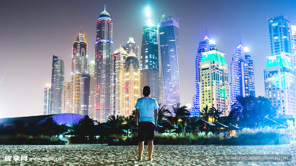 男子眺望滨海都市夜景