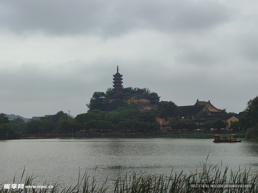 阴天湖畔山间古塔远景