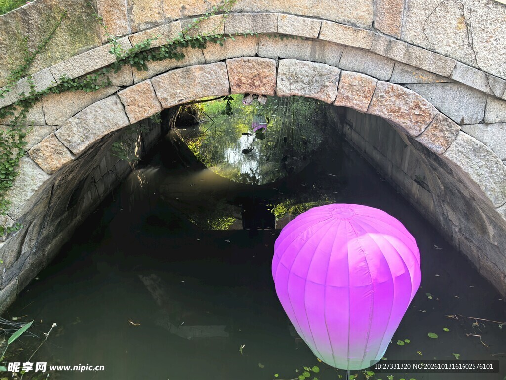 石拱桥下的紫色河灯