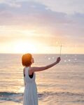 海边日落玩泡泡的少女