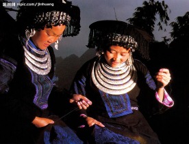 苗族姐妹缝制衣服