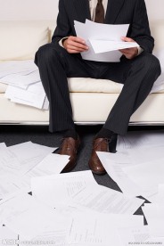 坐在沙发上看文件的商务人物特写 满地的文件